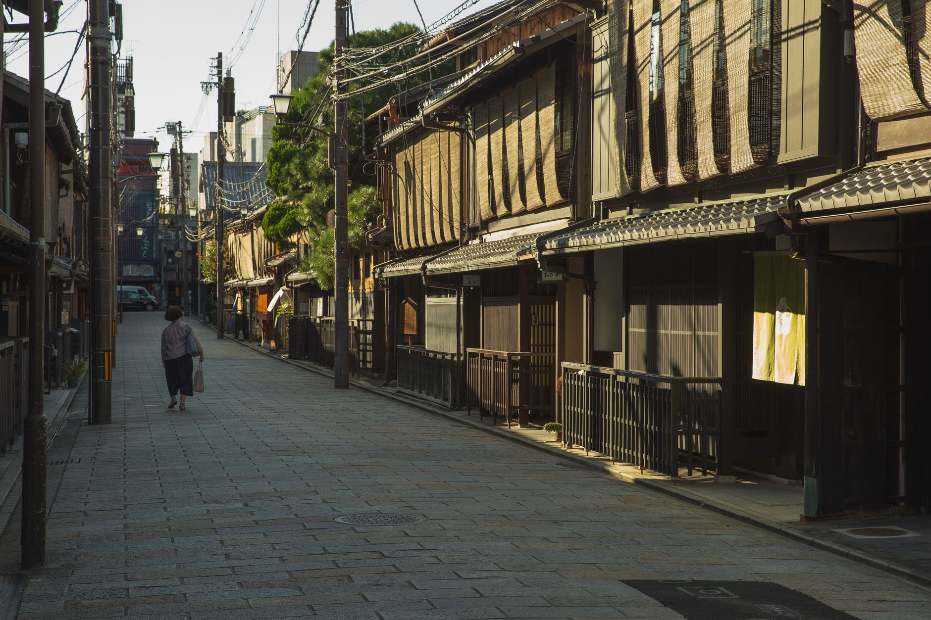 夕暮れの静かな街並みを歩く人の後ろ姿。食後の軽いウォーキングの一場面