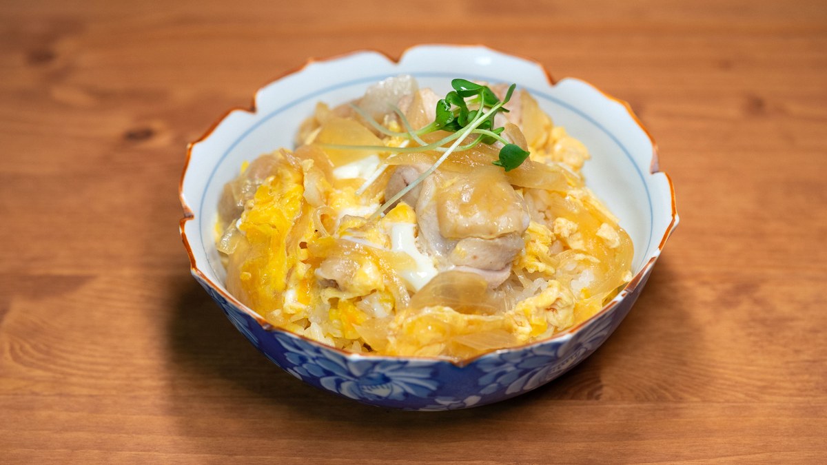 木のテーブルに置かれた、染付の器に盛られた親子丼