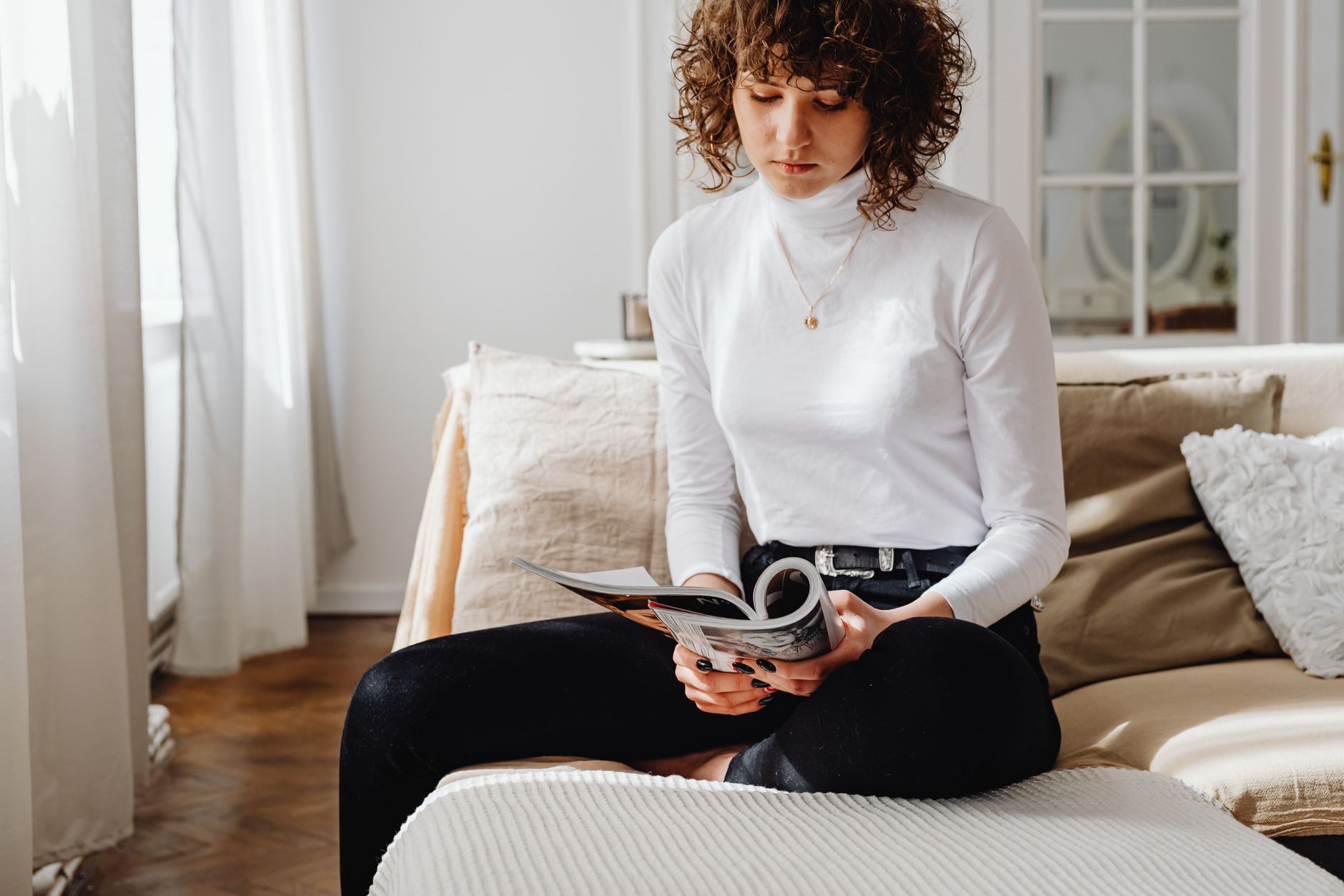 A woman relaxing comfortably at home in soft, bright natural light
