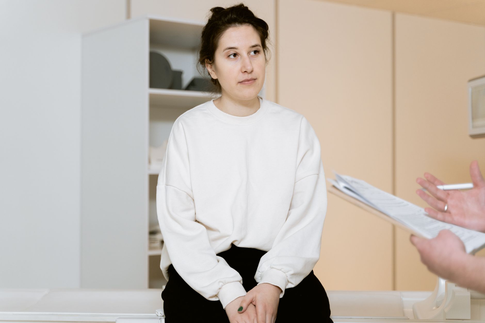 A woman listening attentively during a warm, supportive consultation with her clinician