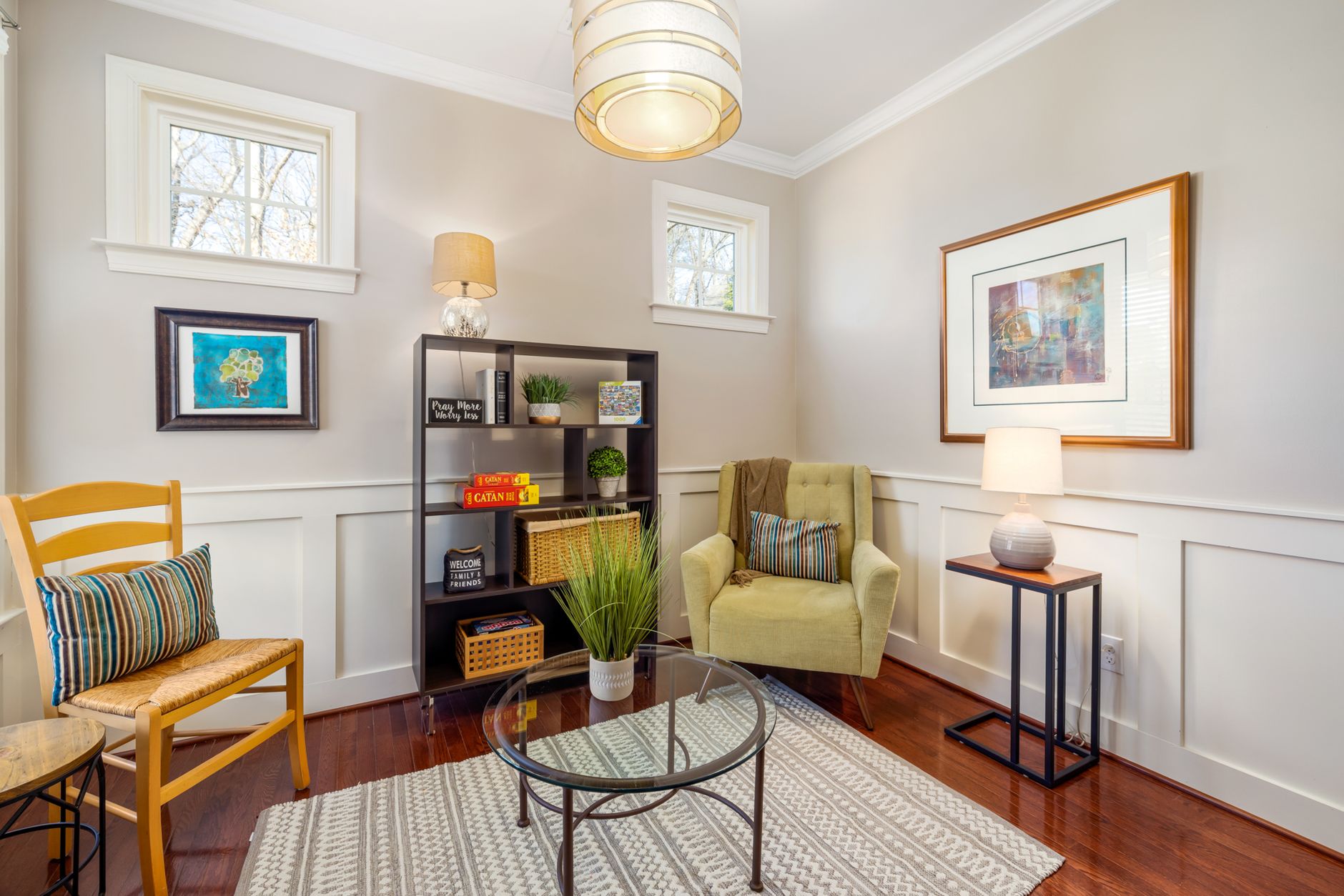 A quiet, softly lit living-room corner with a comfortable armchair, bookshelf and side lamp, conveying a low-stimulation recovery space