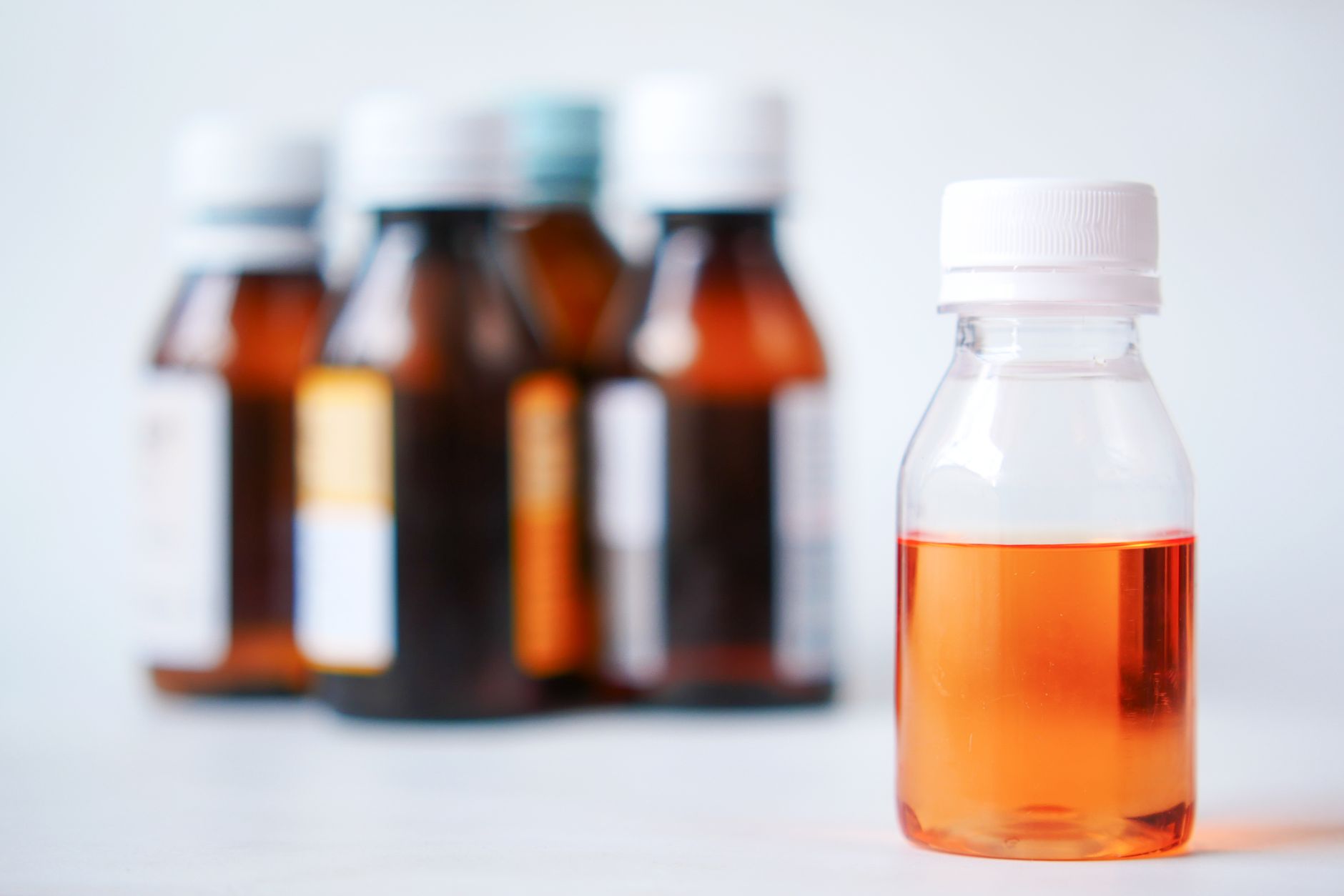 Bottles of children's liquid fever medicine on a bright surface