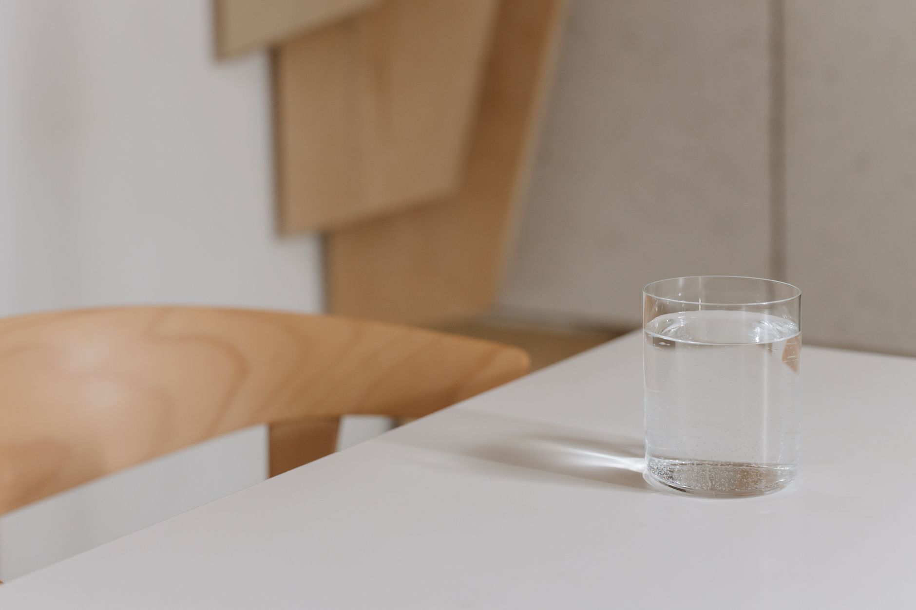 A clean glass of water on a bright, airy table