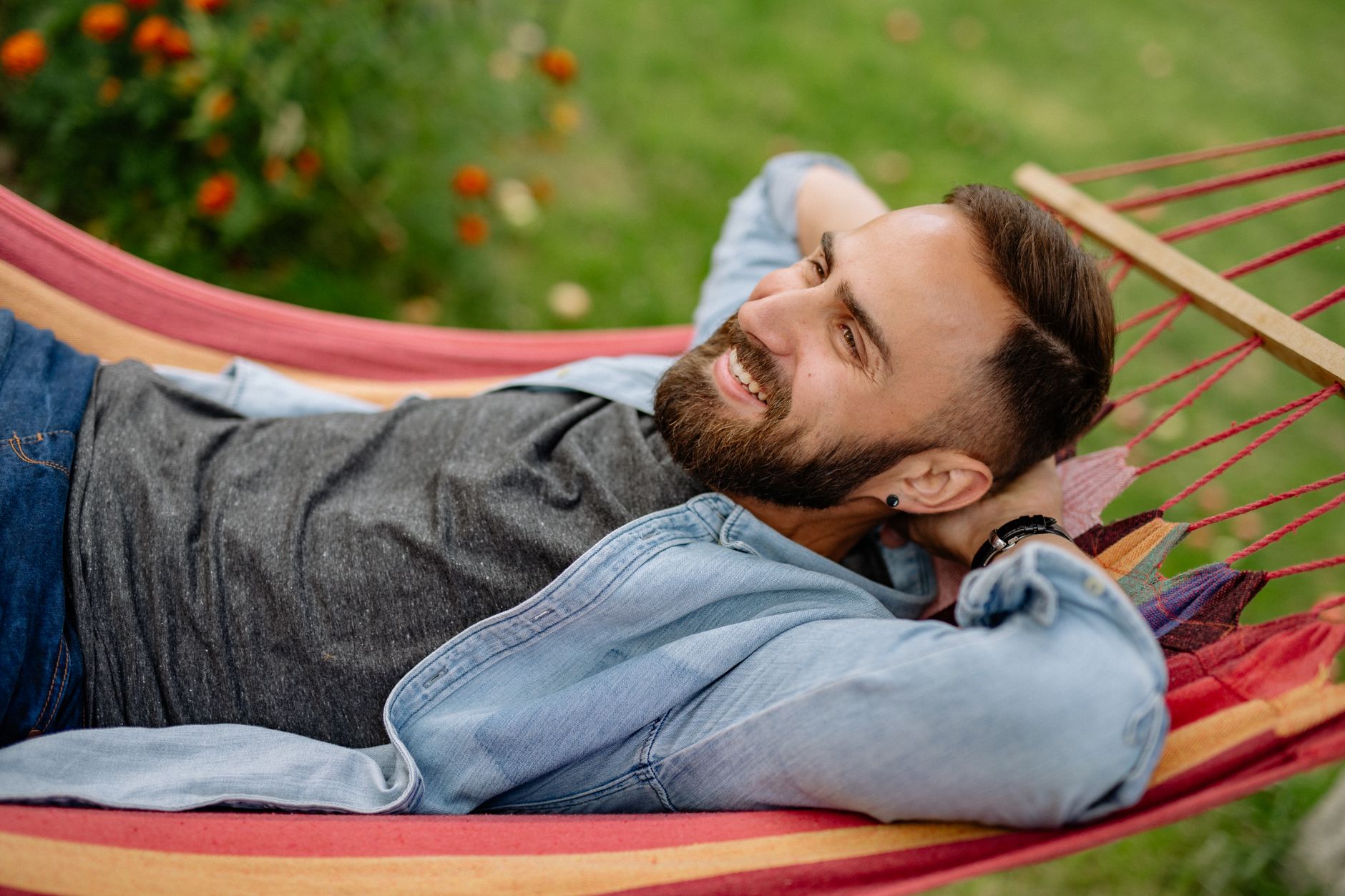 A person resting in a hammock outdoors in soft natural light, genuinely unplugged and at ease