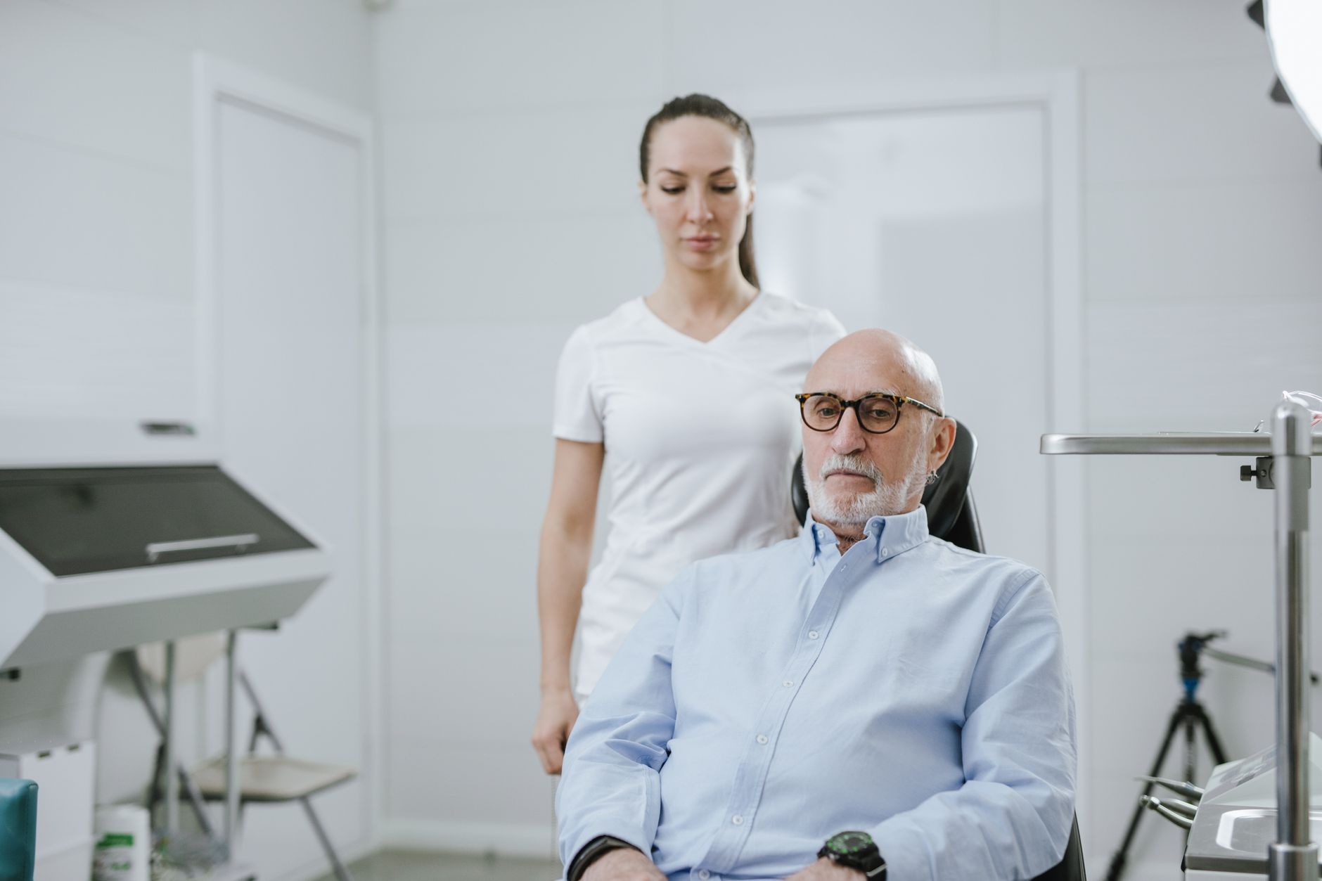 Older man having a bone-health check with a clinician in a bright clinic