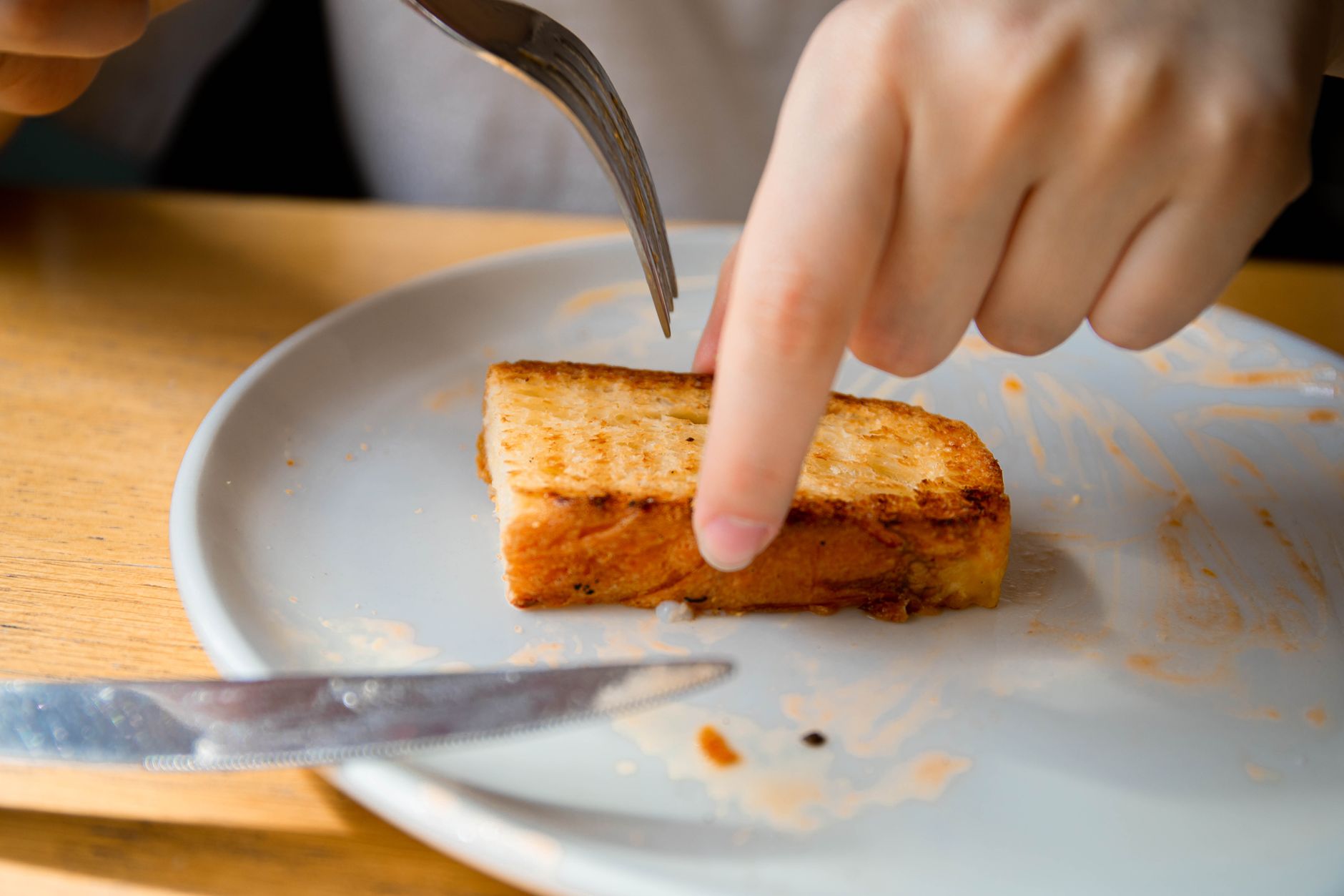 A simple slice of plain toast on a plate, a bland food that can help with nausea