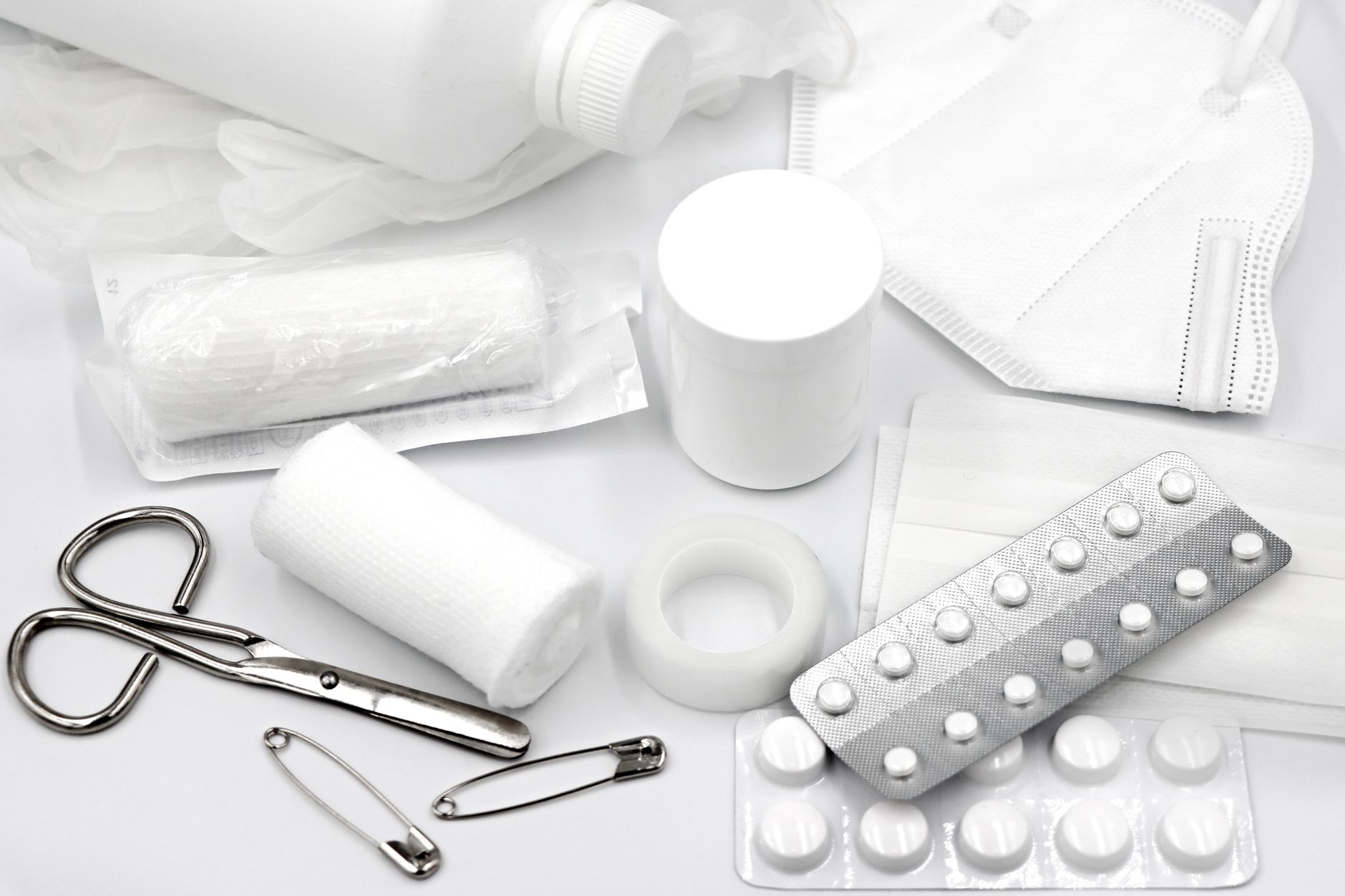 An open home first-aid kit with bandages, gauze, and supplies laid out