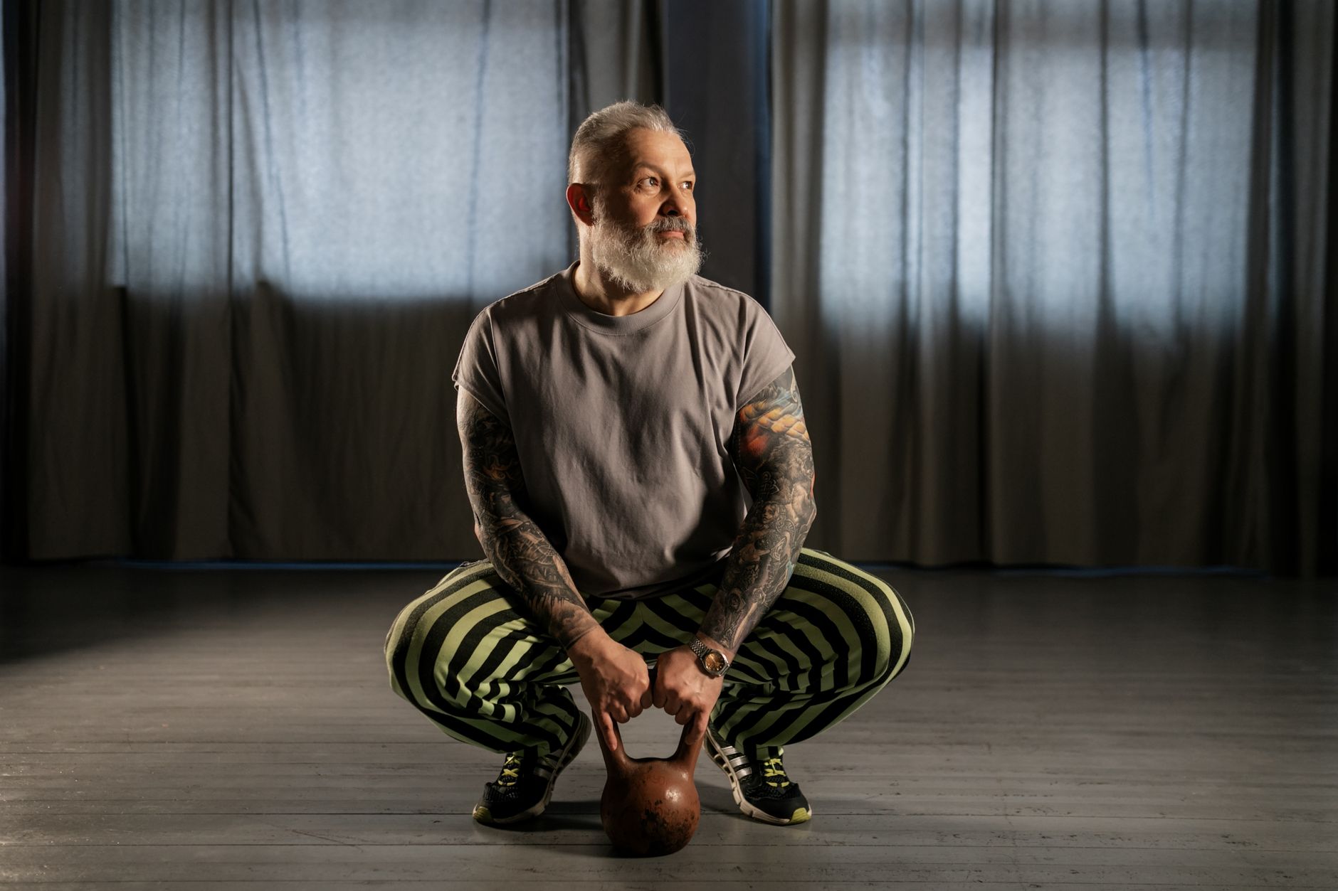 A mature man doing a weighted squat — resistance training is the cornerstone