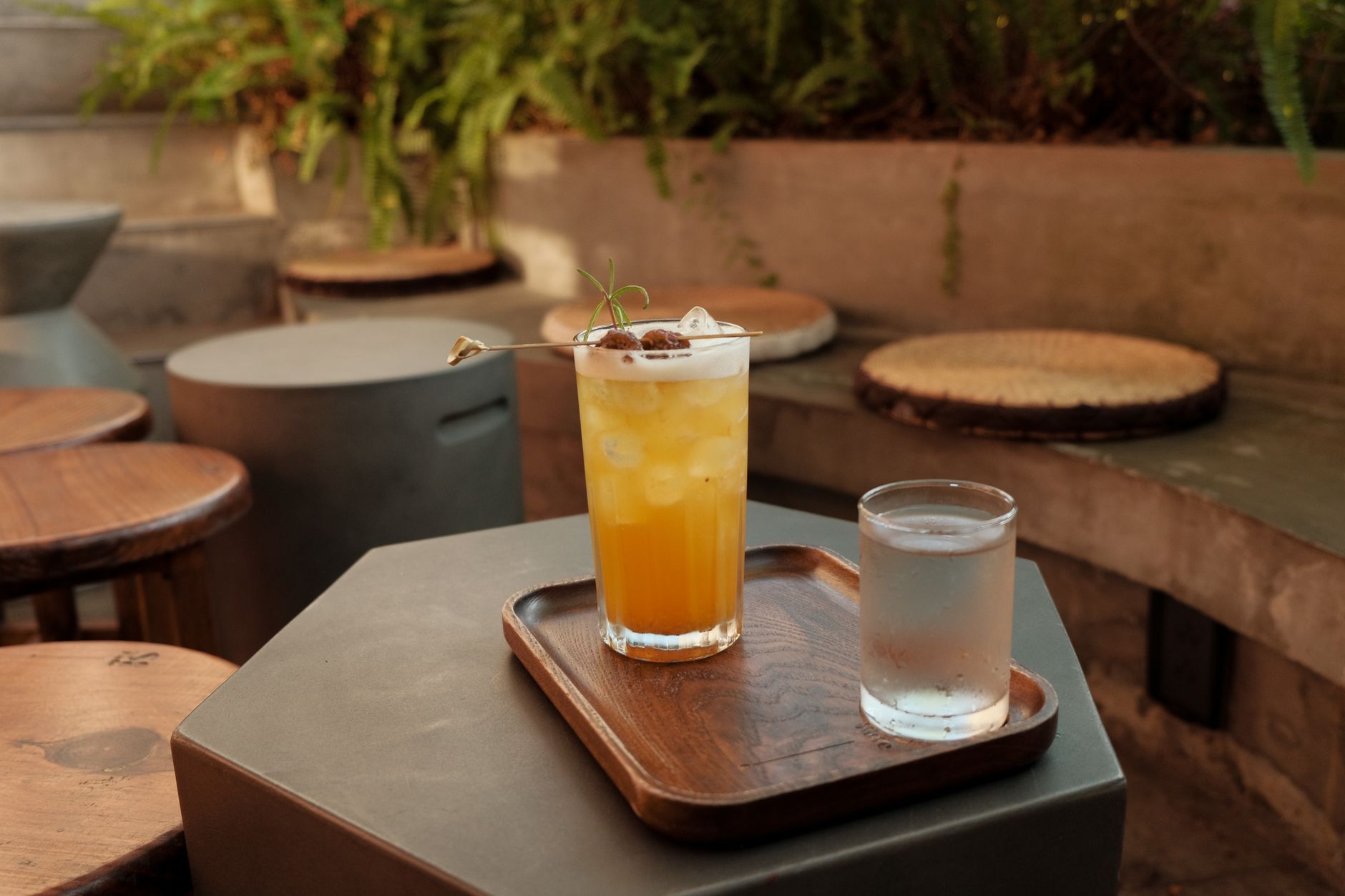 A glass of iced water set next to a drink on the table, a reminder to alternate water between drinks