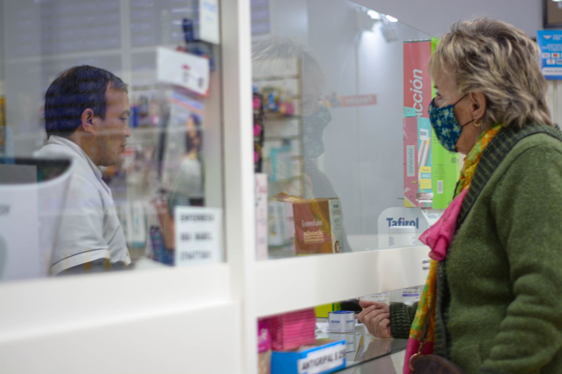 A customer checking with a pharmacist at the counter before buying, confirming which medications suit the device
