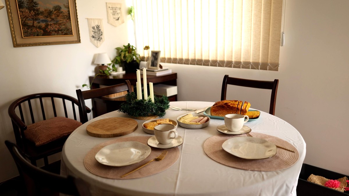 A quiet breakfast table set for two in a home dining room, morning light through the blinds, no people